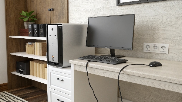 A desktop computer on a desk with a visible wall outlet but no UPS unit