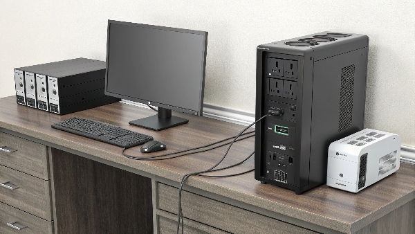 A desktop PC, monitor, and modem/router all plugged into the battery backup outlets of a UPS unit