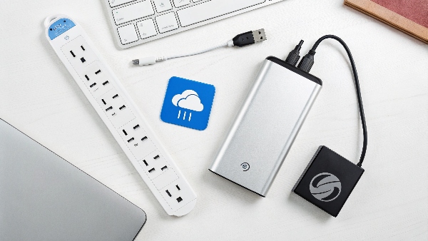 A surge protector power strip, an external hard drive for backups, and a cloud storage icon