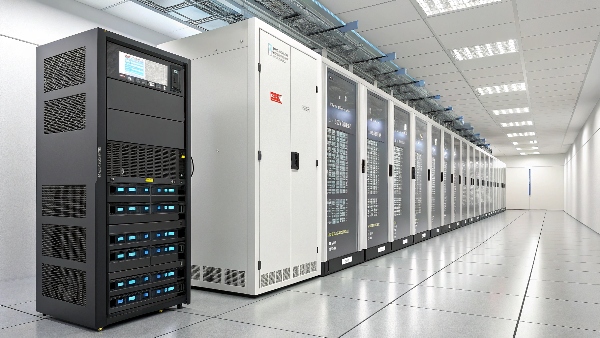 A modern, clean data center aisle with racks of servers, with a large industrial UPS unit visible in the background or foreground