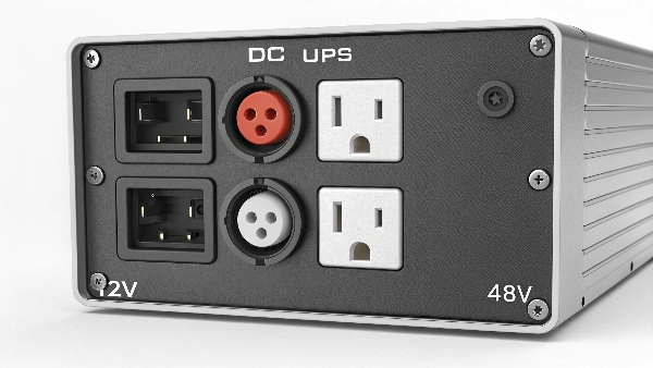A photo of the back panel of a DC UPS showing different types of outputs, like 12V barrel jacks and 48V screw terminals