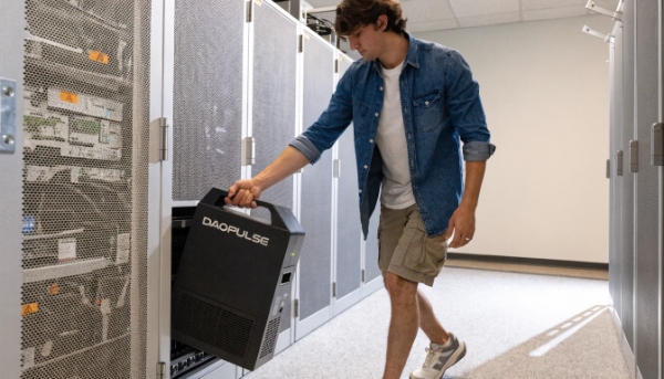 A technician easily sliding a lightweight DAOPULSE lithium-ion battery module into a server rack